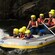 A raft carrying 4 kids, 5 adults and a guide over rapids
